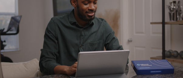 Seated individual gazing at a laptop, concentrating on their work or research