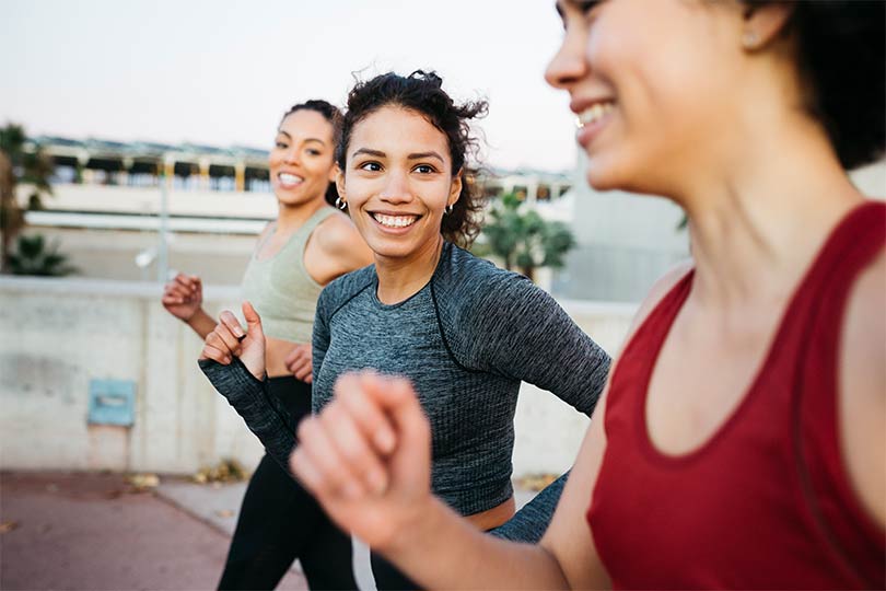 Three women wearing workout clothes going for a run outside, practicing healthy habits for women.