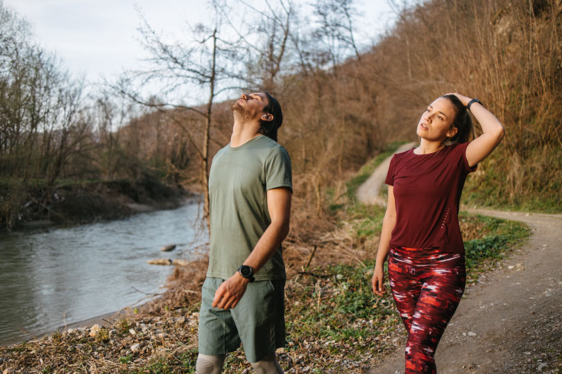 Couple jogs by river.