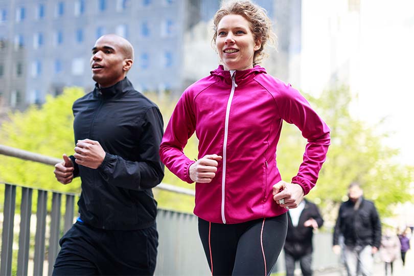 A man and woman outside taking a run, practicing healthy habits for reducing insulin resistance and cardiovascular wellness.