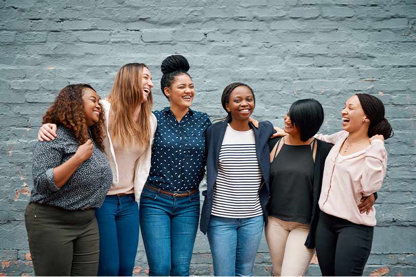 A group of women posing for a picture, sharing stories and experiences about women’s hormone health.