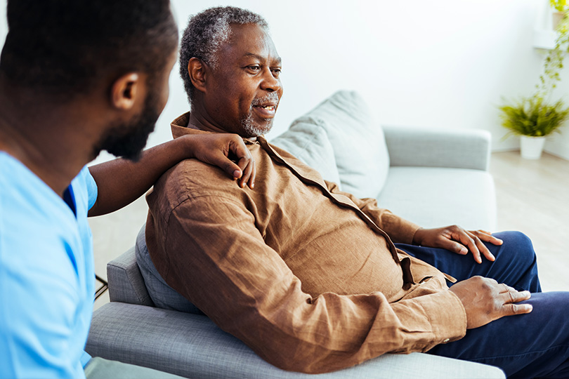 A man consults with a doctor on a couch, discussing the importance of ACR tests for early kidney disease detection.