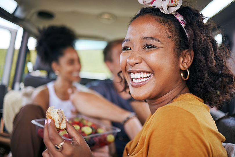 A woman in the back of a car smiles, representing optimism and strength, with an underlying connection to diabetes advocacy.