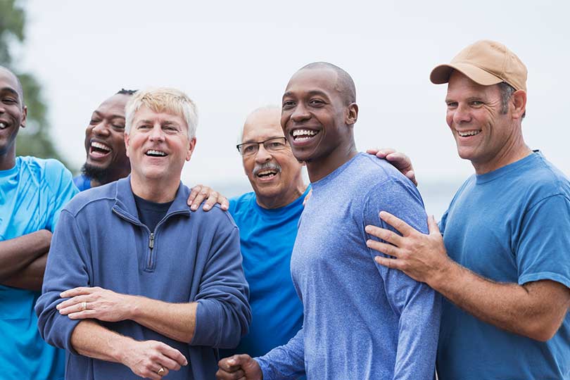 Three older men outside playing basketball, talking about male hormone health.