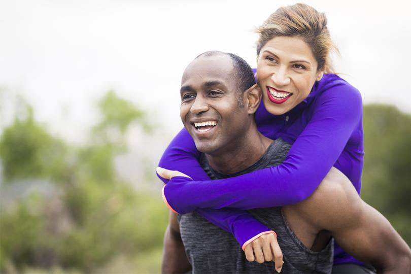 Man gives woman piggyback ride.