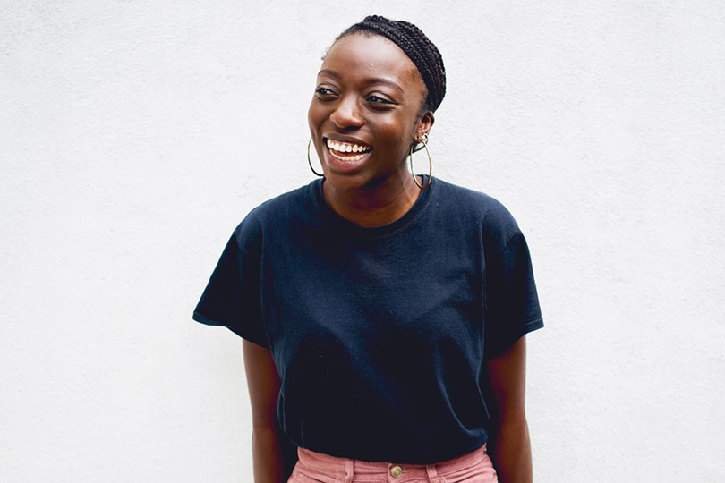 A woman wearing a black t-shirt and pink pants, embodying a commitment to health and wellness for the New Year.