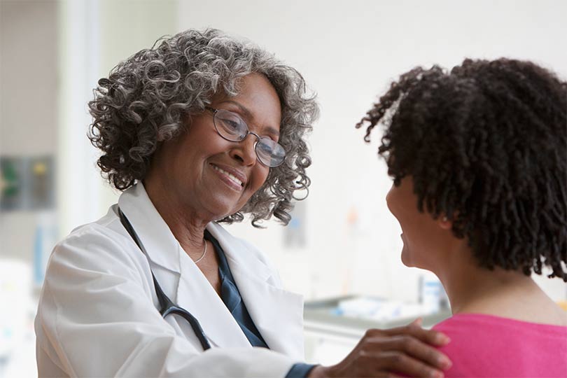 A female doctor talking to a female patient about polycystic ovary syndrome (PCOS) and hormonal health.