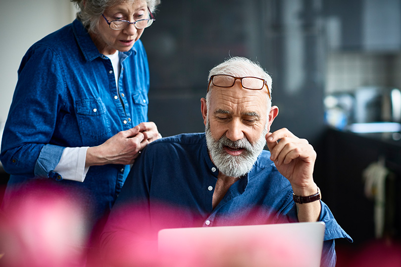 An older couple examines a laptop, symbolizing the importance of technology in understanding CKD diagnosis and treatment.