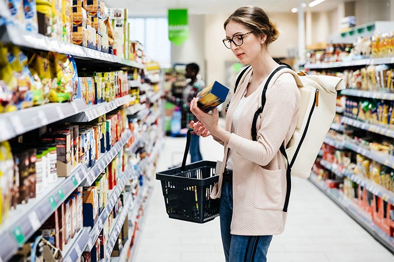 A woman grocery shopping for anti-inflammatory foods to follow an anti-inflammatory diet.