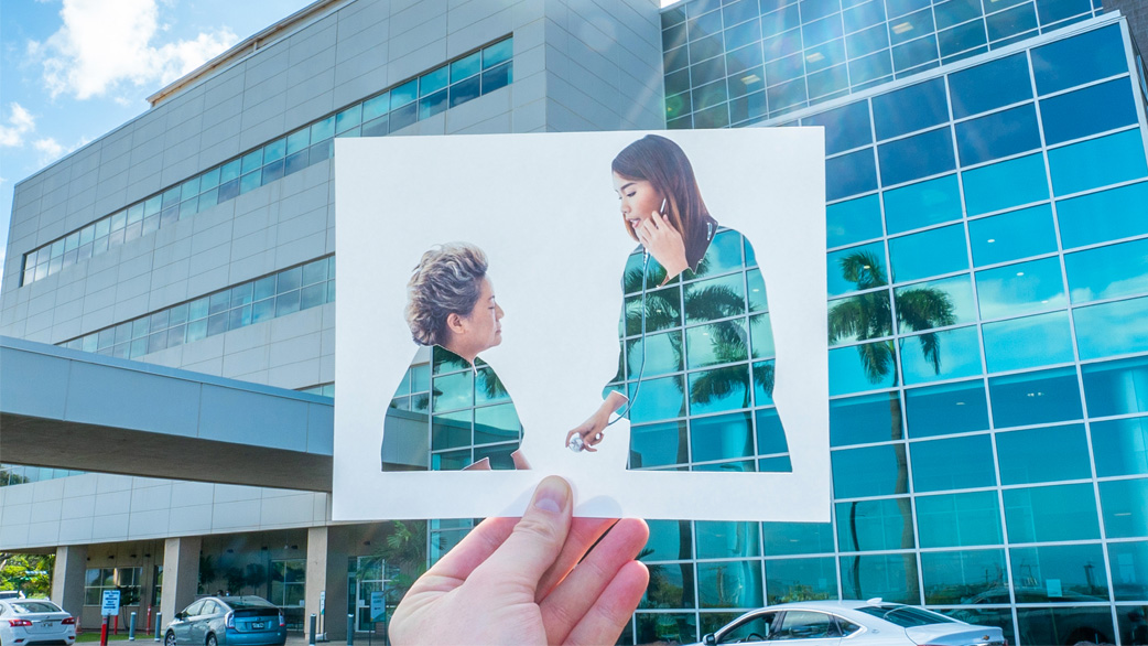 A person holds a photo of a patient during a doctor's checkup, highlighting the connection between patient and caregiver.