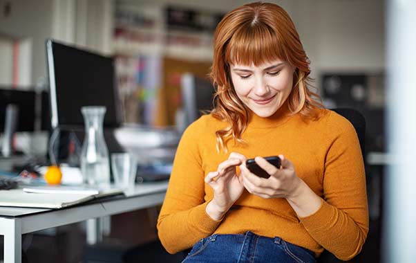 A women looking at the mobile phone with smile