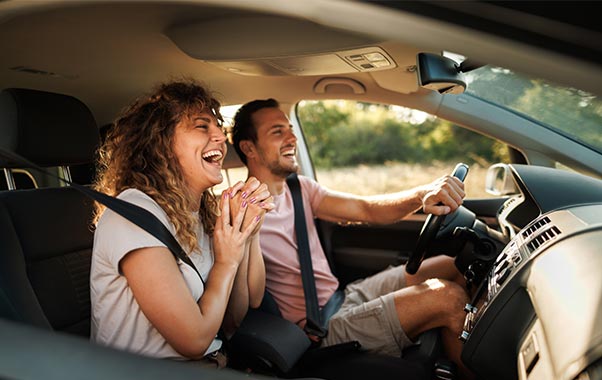 Couple driving through sunny countryside