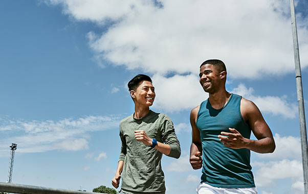Two healthy young males running and staying active for men’s health.