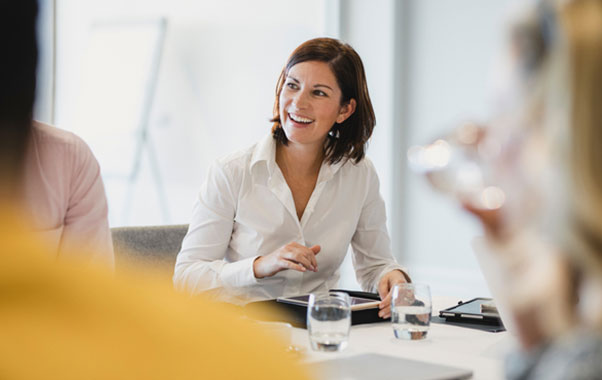 Woman sitting at table with glass of water in front of her