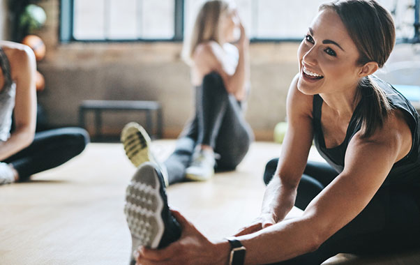 Woman on floor stretching at group fitness class
