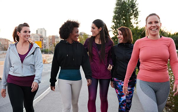 Women in their thirties walking outside talking about women’s health testing.