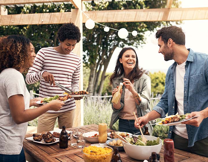 Friends enjoying a meal together outside near the BBQ.