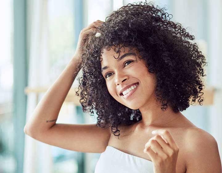 Woman assessing hair health.