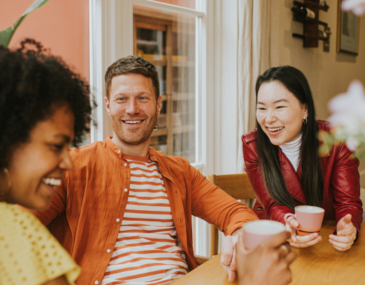 Friends sit around the table sharing happy conversation.