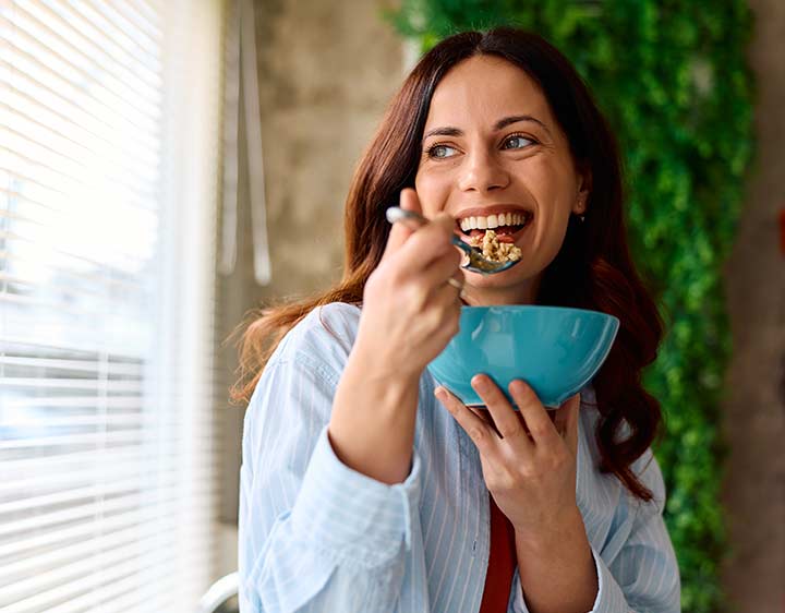 A woman eats happily after better understanding her digestive health