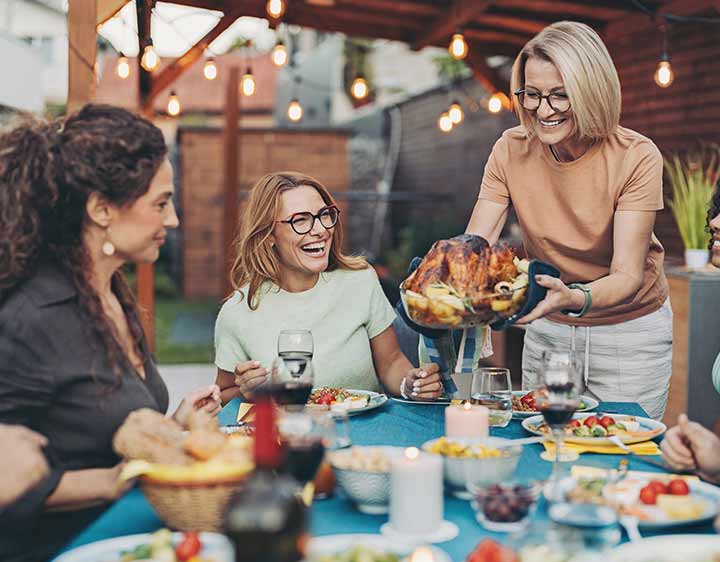 A happy group of people enjoying a keto friendly meal together outside