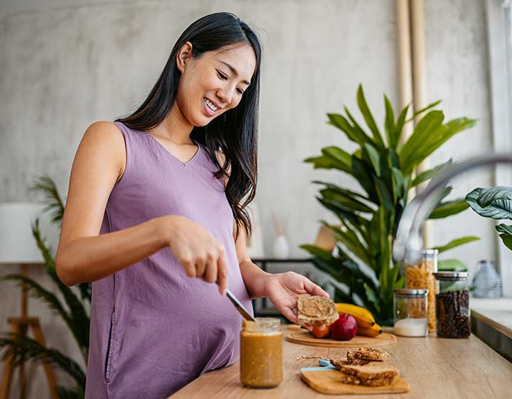 Pregnant woman preparing nutritious meal.