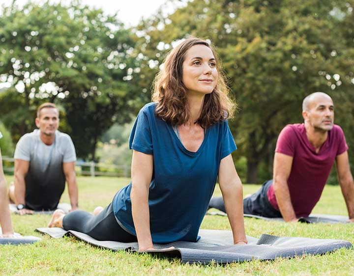 Woman doing a yoga class outside in a park