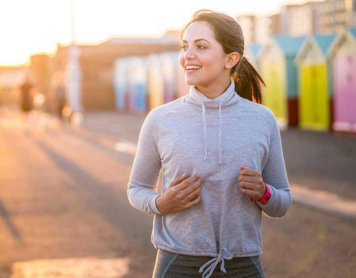 A smiling woman running on the boardwalk reassured after receiving the results for her blood tests