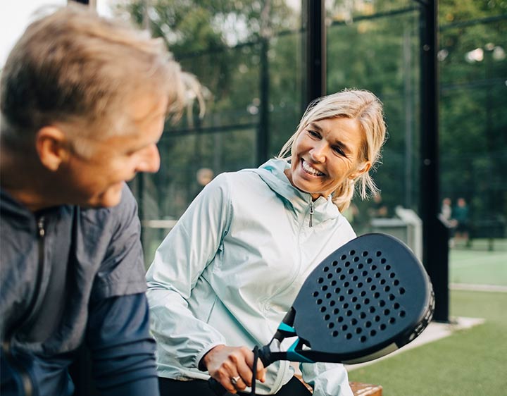 Men and women happily playing together outdoors.