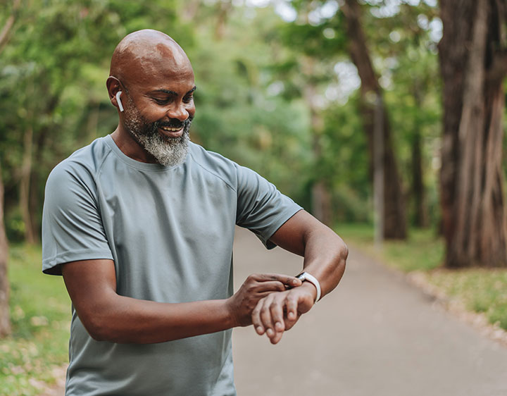 Man outdoors checking health watch.