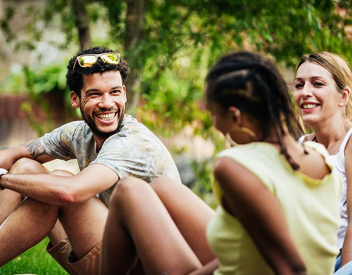 Man sitting outside socializing with friends outdoors, representing consideration of Free T3 Testing.