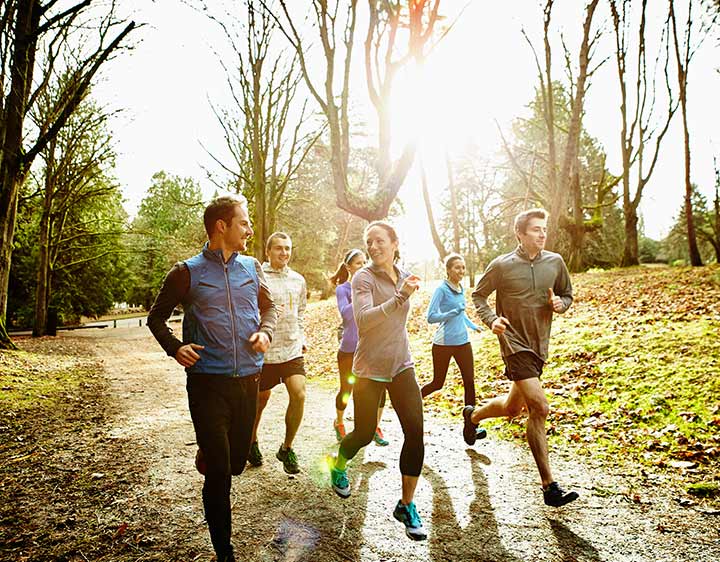 Group of millennials running outdoors proactive about health.