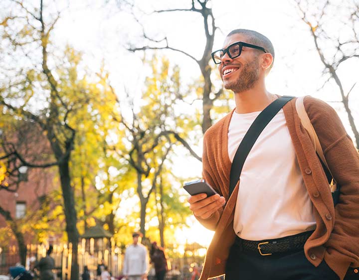 A happy man walking with his phone after checking his test results