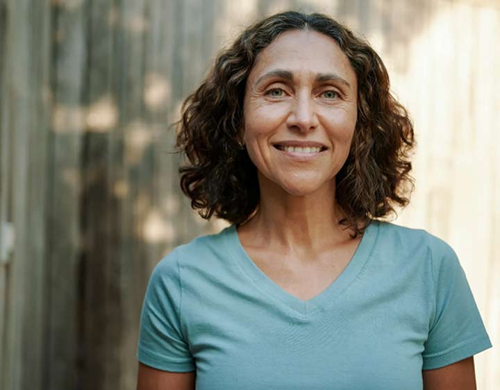 A woman looks happily at the camera after understanding her genetic risk profile
