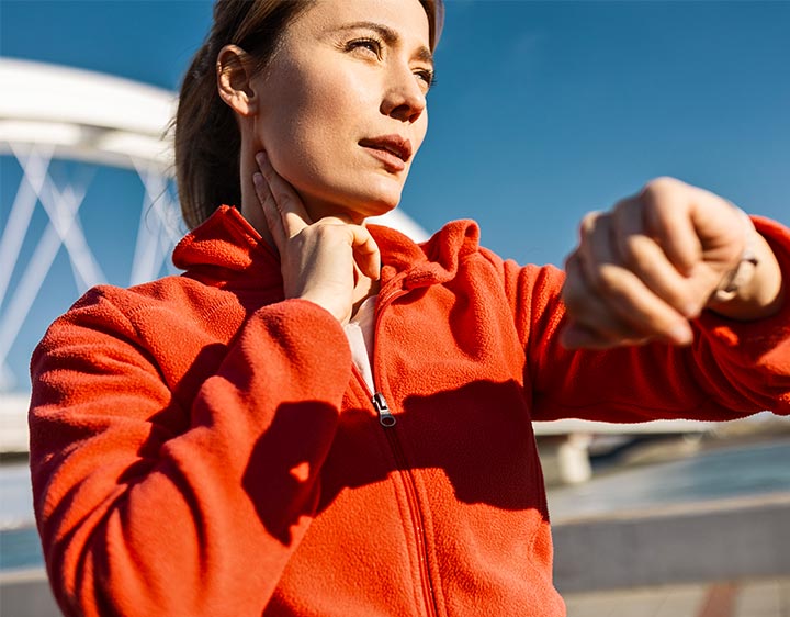 Woman checking her heart rate while exercising outside