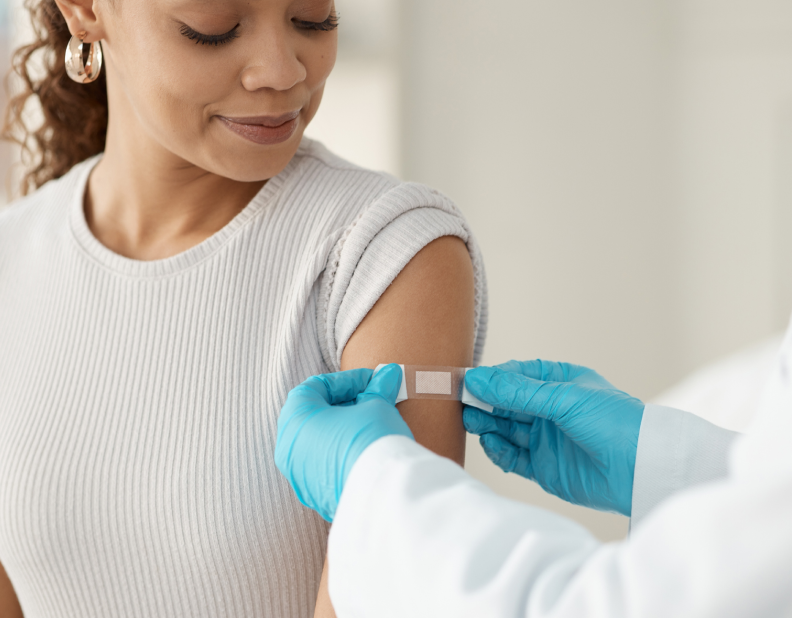 Nurse applies band aid after giving vaccine.