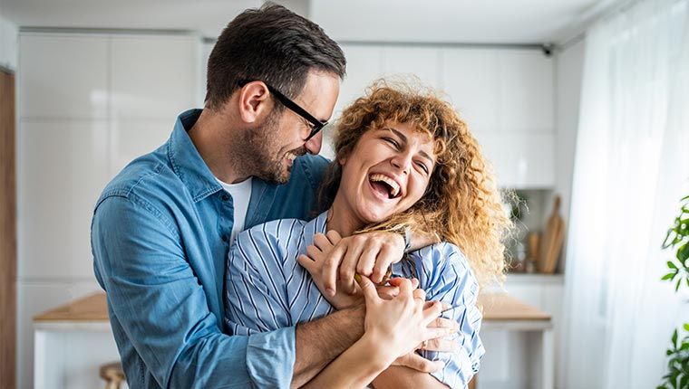 A happy couple inside their home.