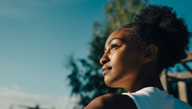 Woman in kitchen making fruit salad.