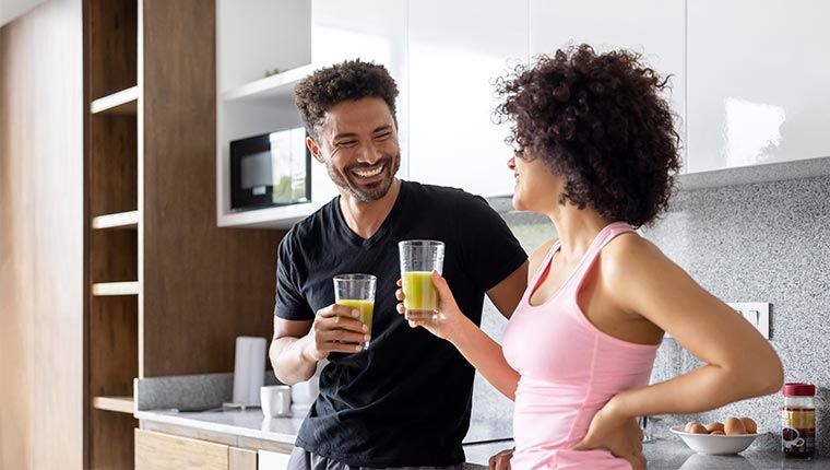 Man and woman drinking green juice for gut health.