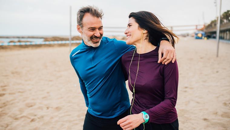 Man and woman jogging outdoors representing heart health and wellness lifestyle choices related to ApoB testing.
