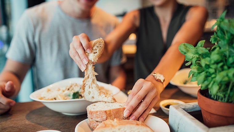 A couple eats bread for dinner.