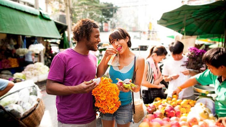 Man and women walking and eating fruit showing healthy cortisol levels.