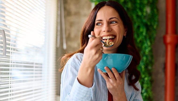 A woman eats happily after better understanding her digestive health.