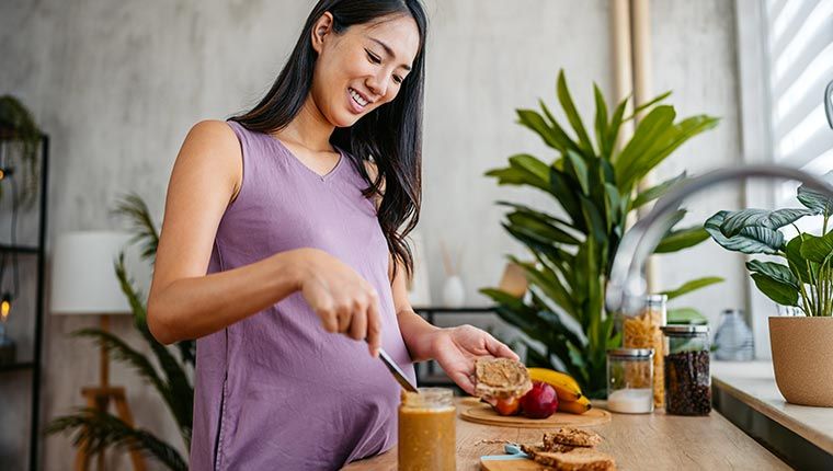 Pregnant woman preparing nutritious meal.