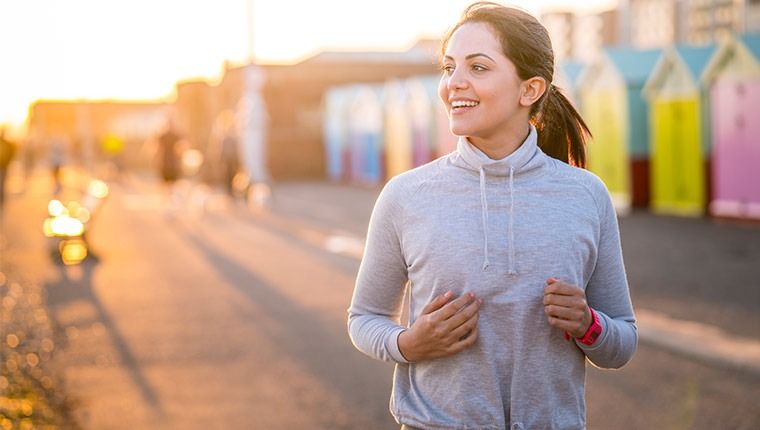 A smiling woman running on the boardwalk reassured after receiving the results for her blood tests.