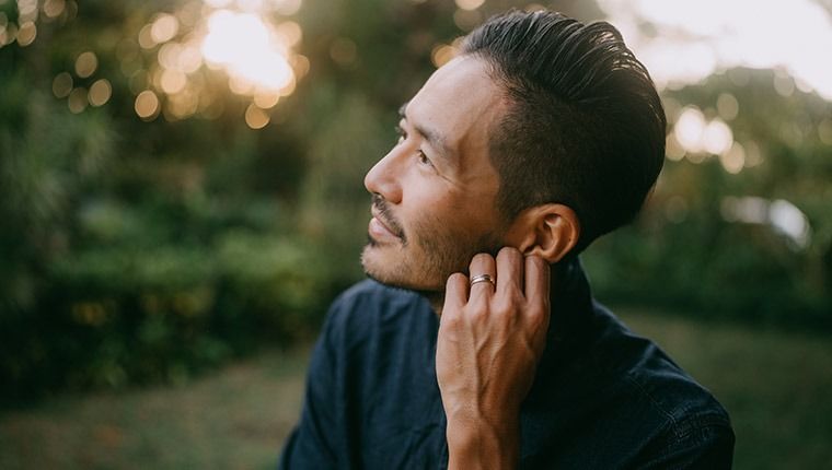 Healthy man looking into sunny sky.