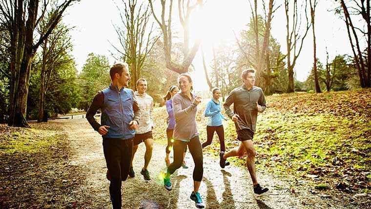 Group of millennials running outdoors proactive about health.