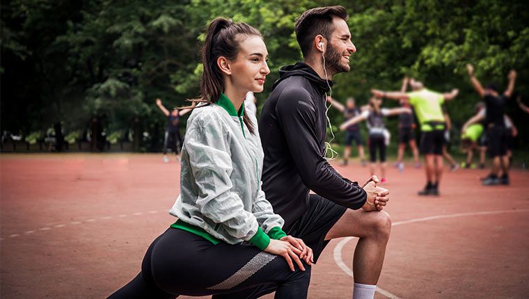 Man and women outdoors exercising.