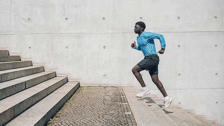 Man running stairs outdoors, representing active lifestyle and men's health.