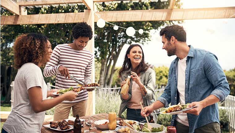 Friends enjoying a meal together outside near the BBQ.